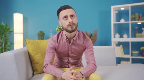 Unglücklicher Mann, tief in Gedanken allein zu Hause. Der Mensch denkt über sein Unglück und seine Trauer nach.