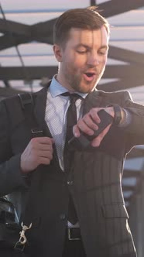 Successful Businessman Checks Watch and Smiles Outdoors