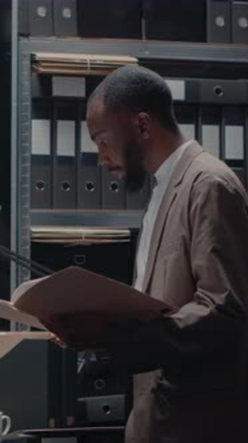 Man in Suit Reviews Files in Office