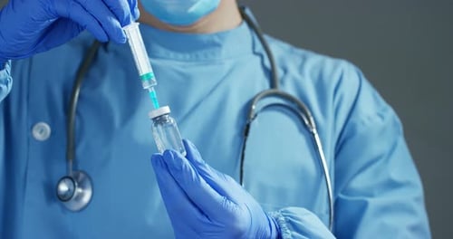 Medical Professional Draws Liquid Into Syringe