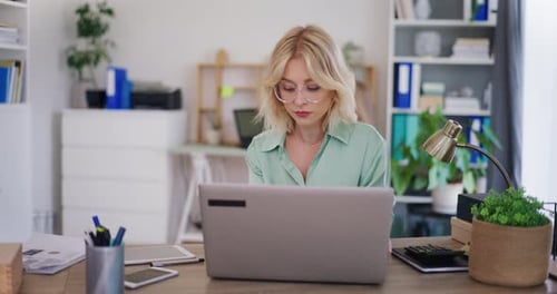 Woman Focused on Work on Laptop in Office