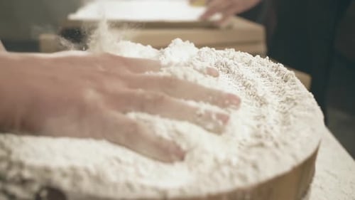 Hand Pushing Through White Baking Flour