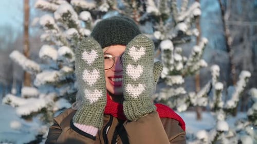 Portrait Happy Winter Woman Playing Hiding Face Mittens Heart Pattern at Sunny Snowy Forest Closeup