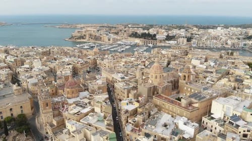 A pull back reveal 4k aerial drone footage of the cityscape of the 'Three Cities of Malta' along the