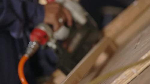 Man Using Nail Gun to Attach Wood Pieces