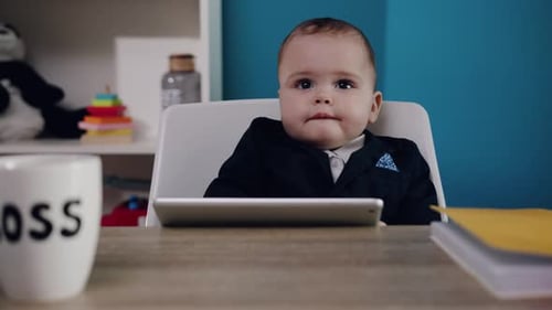 Baby Sits at Desk Wearing a Suit