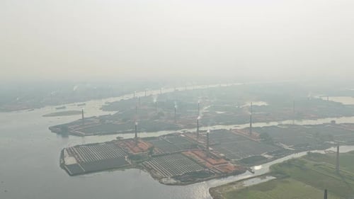 Drone shot of brick field production with smoke and workers in Bangladesh
