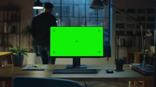 Desktop Computer with Mock-up Green Screen Standing on the Desk in the Modern Creative Office. In t