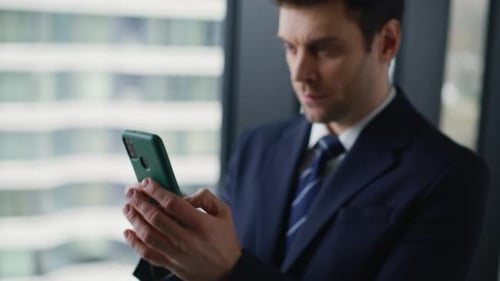 Wealthy Businessman Texting Mobile Phone Standing By Office Window Closeup