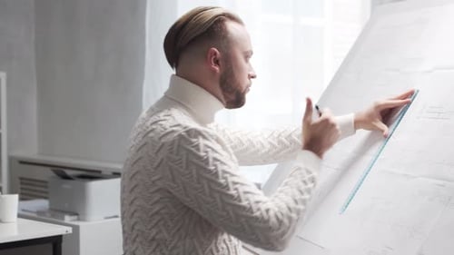 Concentrated Architect Works in Loft Using Drawing Board Workplace of Young Engineer in Modern