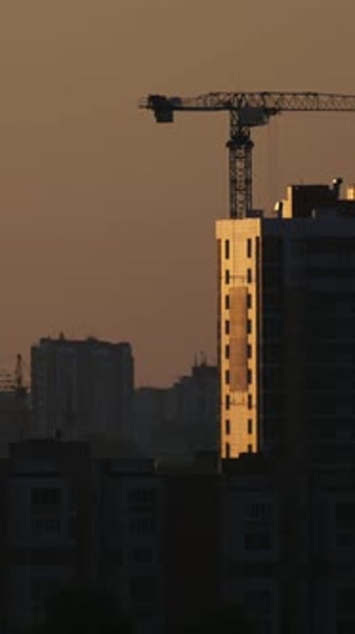 Construction Cranes Near Residential Apartments View on Sunrise