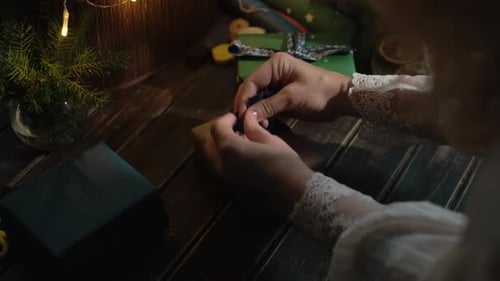 Woman Tying Ribbon Around Holiday Gift
