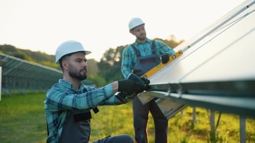 Techniker installieren Sonnenkollektoren auf einer Farm