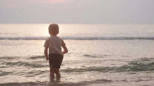 Young Child Running on a Beach at Sunset
