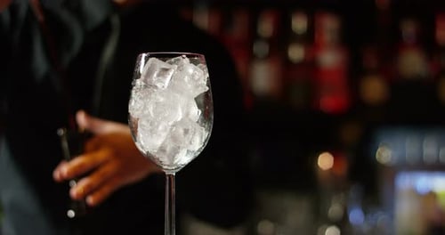 in a nightclub or pub, a professional bartender preparing a cocktail with ice a mix of alcohol. Th