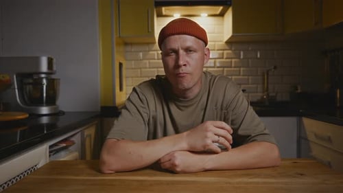 Man Drinking Water at Kitchen Table Indoors