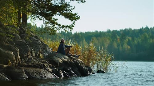 Contemplation And Meditation In Nature Young Woman Sitting Alone On Coast Of Lake In Forest