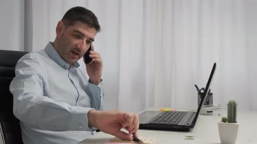 Dolly Portrait Shot business male working from home office, typing on laptop having phone call