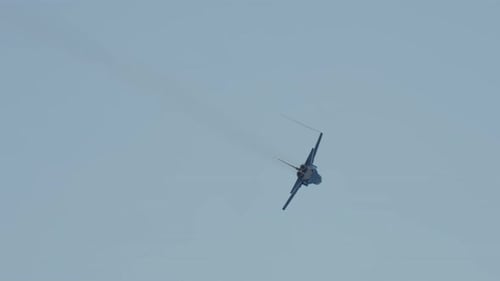 Fighter Jet Performs HighSpeed Turn in Blue Sky