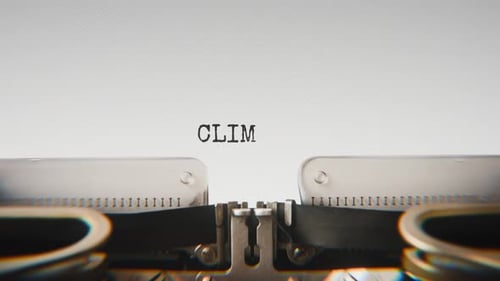 Old mechanical typewriter typing Climate Impact in a close-up view.