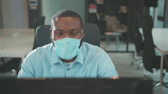 African American Man Removes Mask Uses Computer for Work in Modern ...
