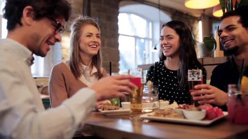 Friends Enjoying Drinks and Snacks Together in Restaurant
