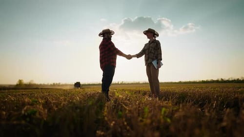 Farmers Shaking Hands in a Field at Sunset
