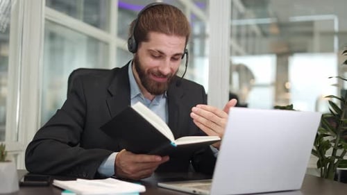 Man With Headset Talking Into Laptop in Office