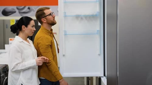 Couple Open Door of the Refrigerator in the Hardware Electronics Store and Compare with Other Models