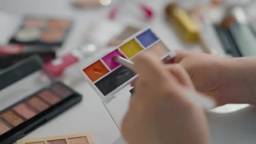 Frau verwendet hellen Lidschatten für Make-up Nahaufnahme von Kosmetikpinseln in den Händen Professionelles Make-up