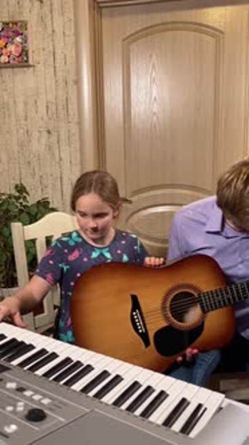 Child Learning Guitar with an Adult at Home