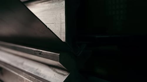 The Process of Bending Metal on a Bending Machine Closeup Work Safely A Gloved Hand Operator Holds