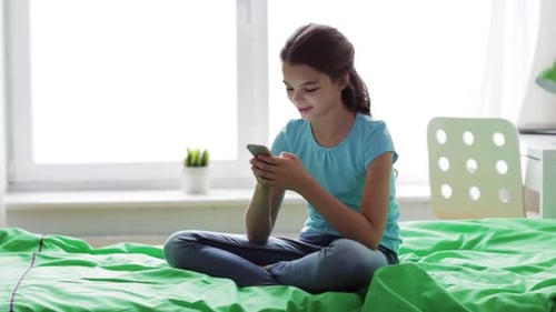 Teen Girl Using Smartphone on Bed at Home