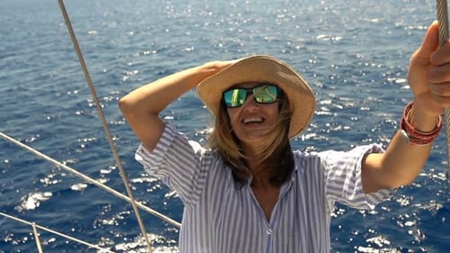 Carefree young woman enjoys sailing boat trip on the sea in super slow motion