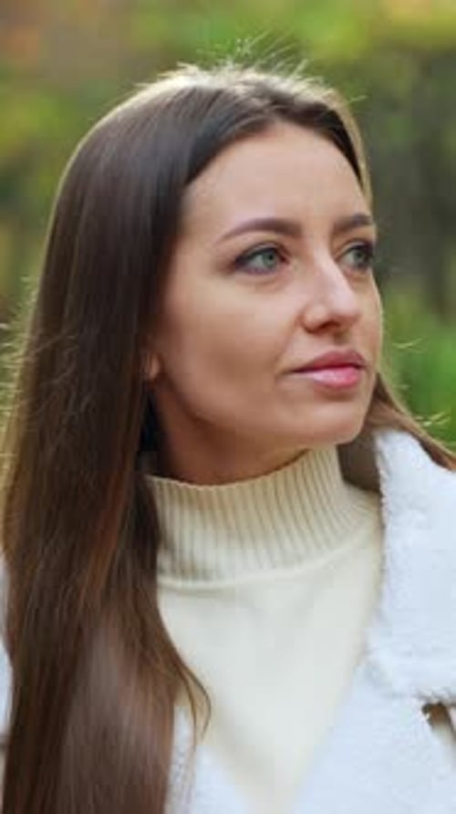 Woman Drinking Beverage Outdoors in Park Setting