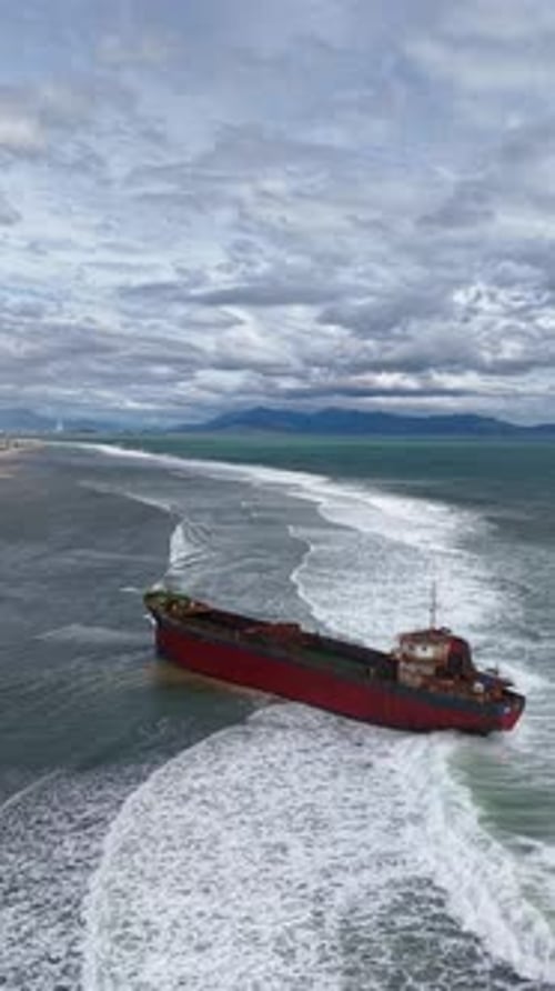 Aerial view, top view of old rusty stranded logistics ship on the beach