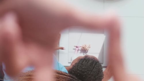 Young Attractive African American Business Woman Hangs Picture on Wall in Office