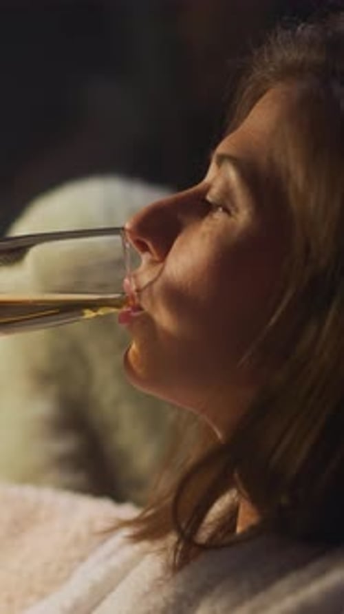 Composed Young Woman Takes Sip of Alcoholic Beverage