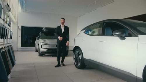 Professional Man Poses in Modern Car Dealership