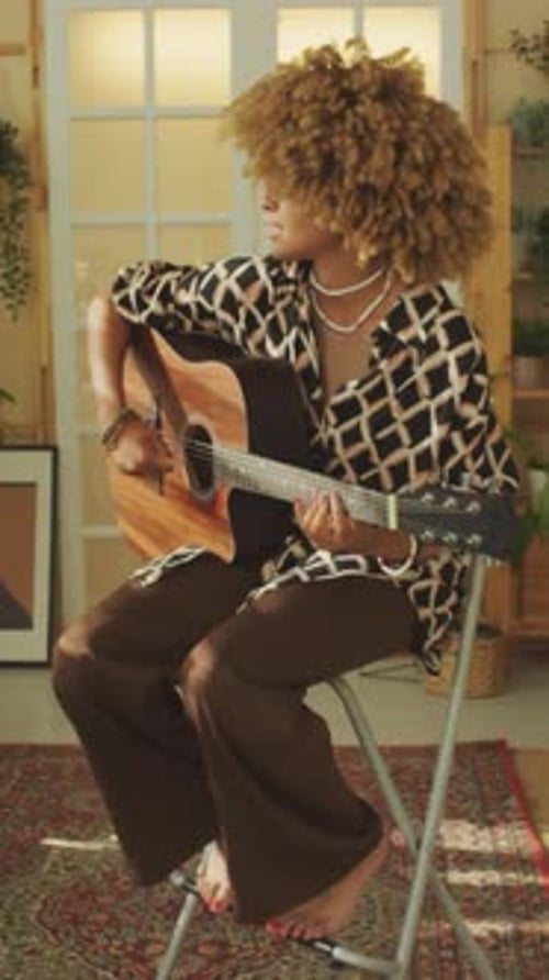 Woman Plays Guitar Sitting Indoors