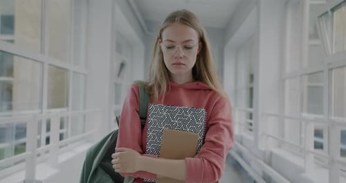 Slow Motion Portrait of Upset Young Woman Walking in High School Hallway Holding Books Feeling Sad