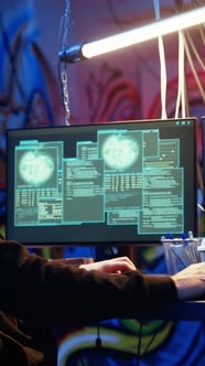 Vertical Video Hooded Hacker Running Code in Graffiti Painted Basement ...