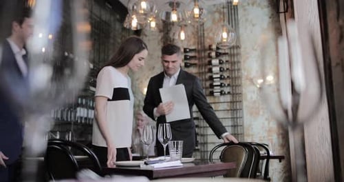 Waiter seating couple in a restaurant