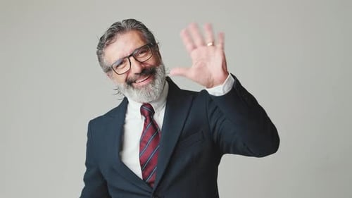 Man in Suit Waving Hello and Smiling