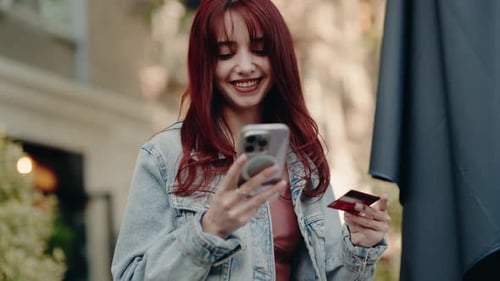 Woman Using Mobile Phone and Credit Card Outdoors