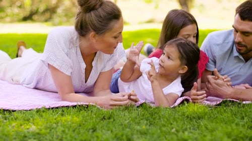 Happy family lies on blanket in the park