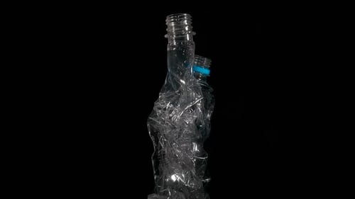 Crumpled Plastic Bottles Rotating on Black Background