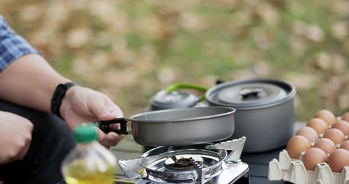 Close-up of frying a tasty fried egg in a hot pan at the campsite