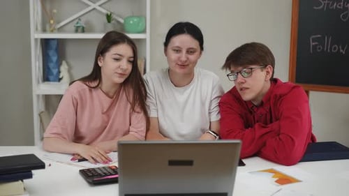 Three Young Adults Studying and Using a Laptop