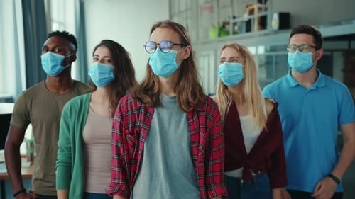 Confident Team Poses with Masks in Modern Office